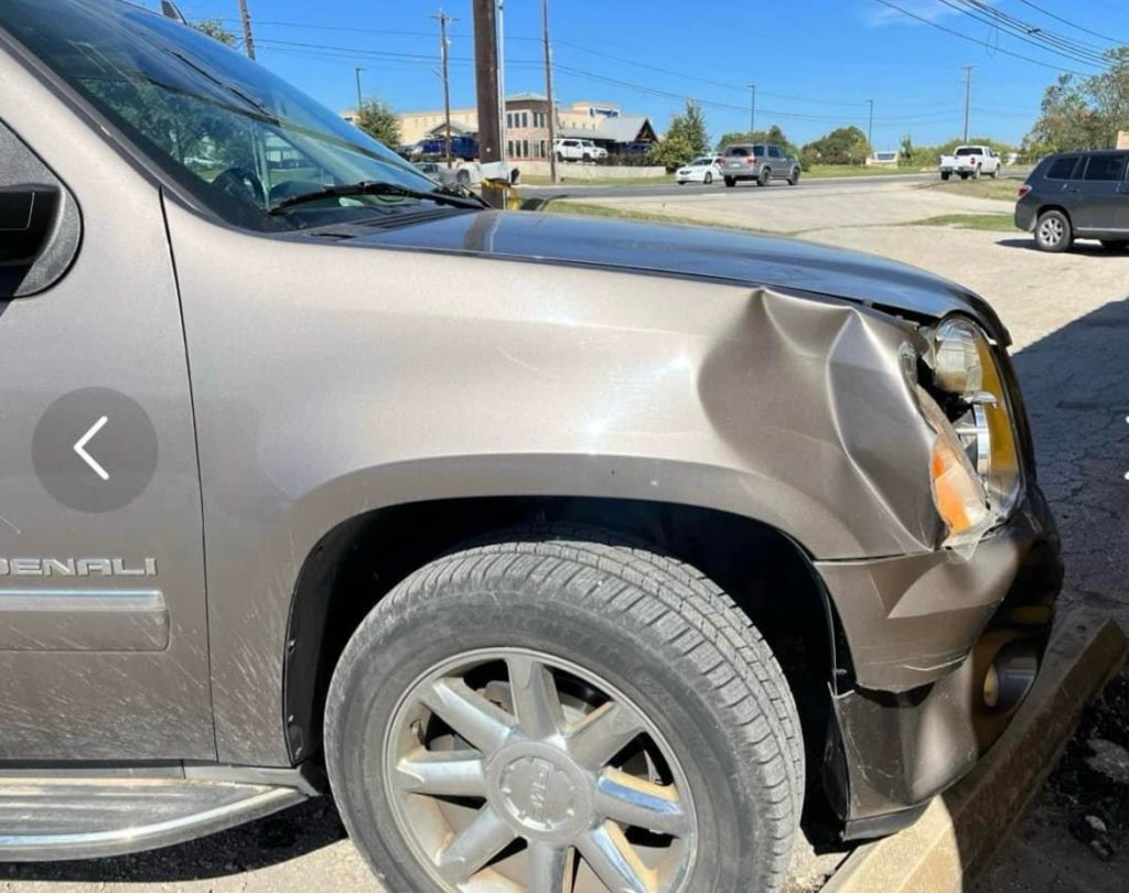 Car with a dented front panel and broken headlight.